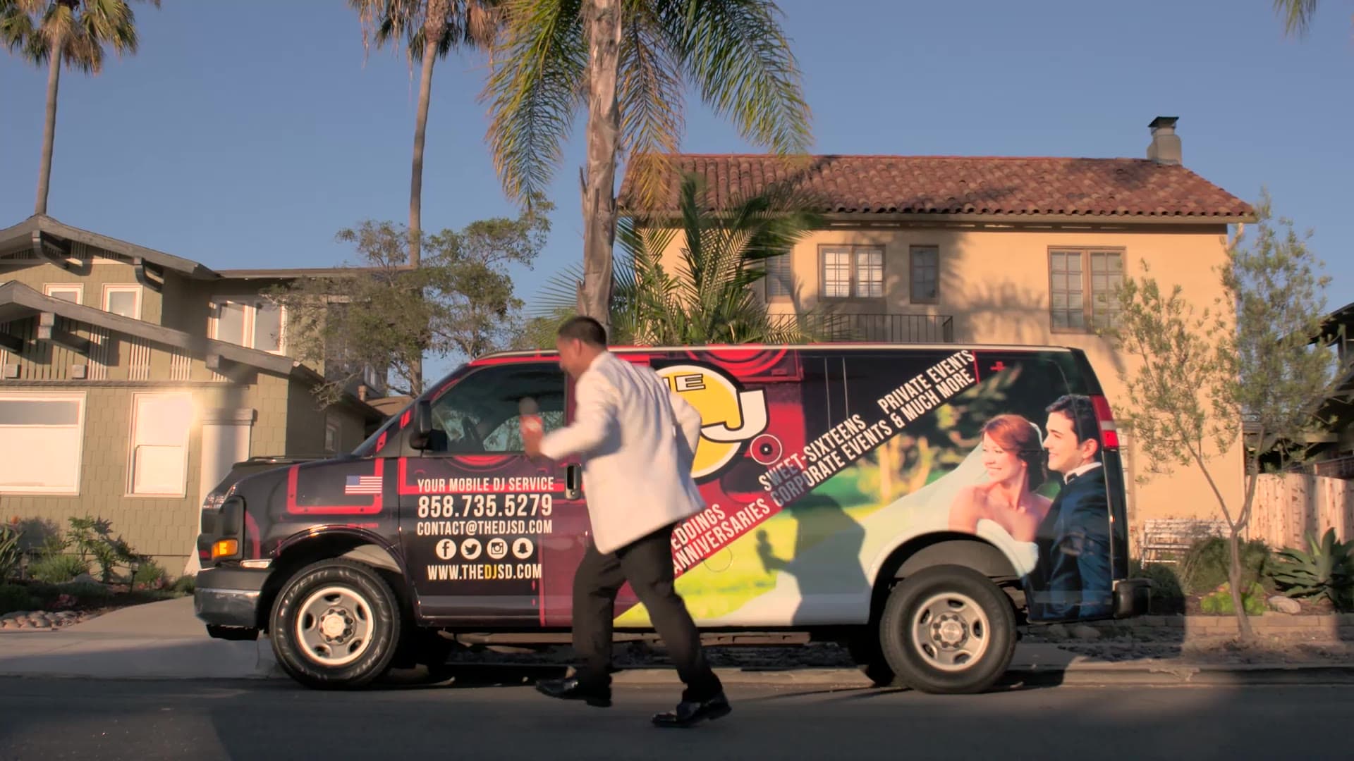 The DJ dancing in the street beside The DJ Company of San Diego van