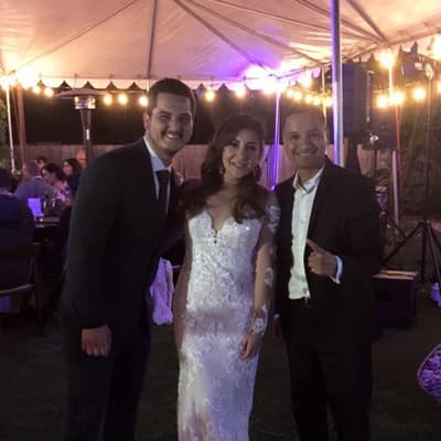Bride, groom and the DJ under a string-lit tent at night