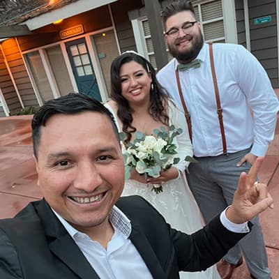 The DJ taking a selfie with a bride and groom